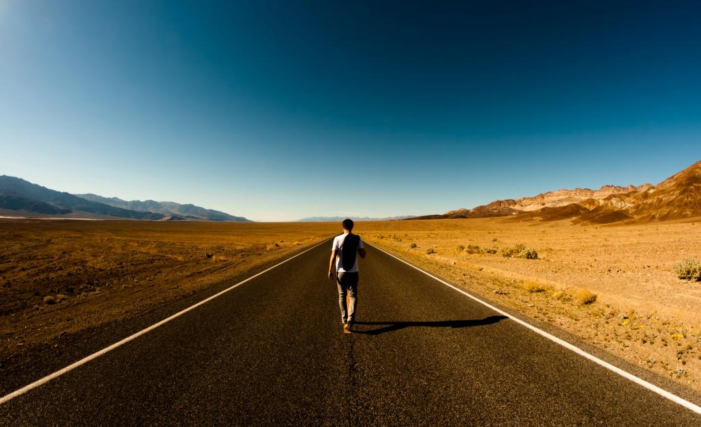 Мужчина бежит по пустой дороге.